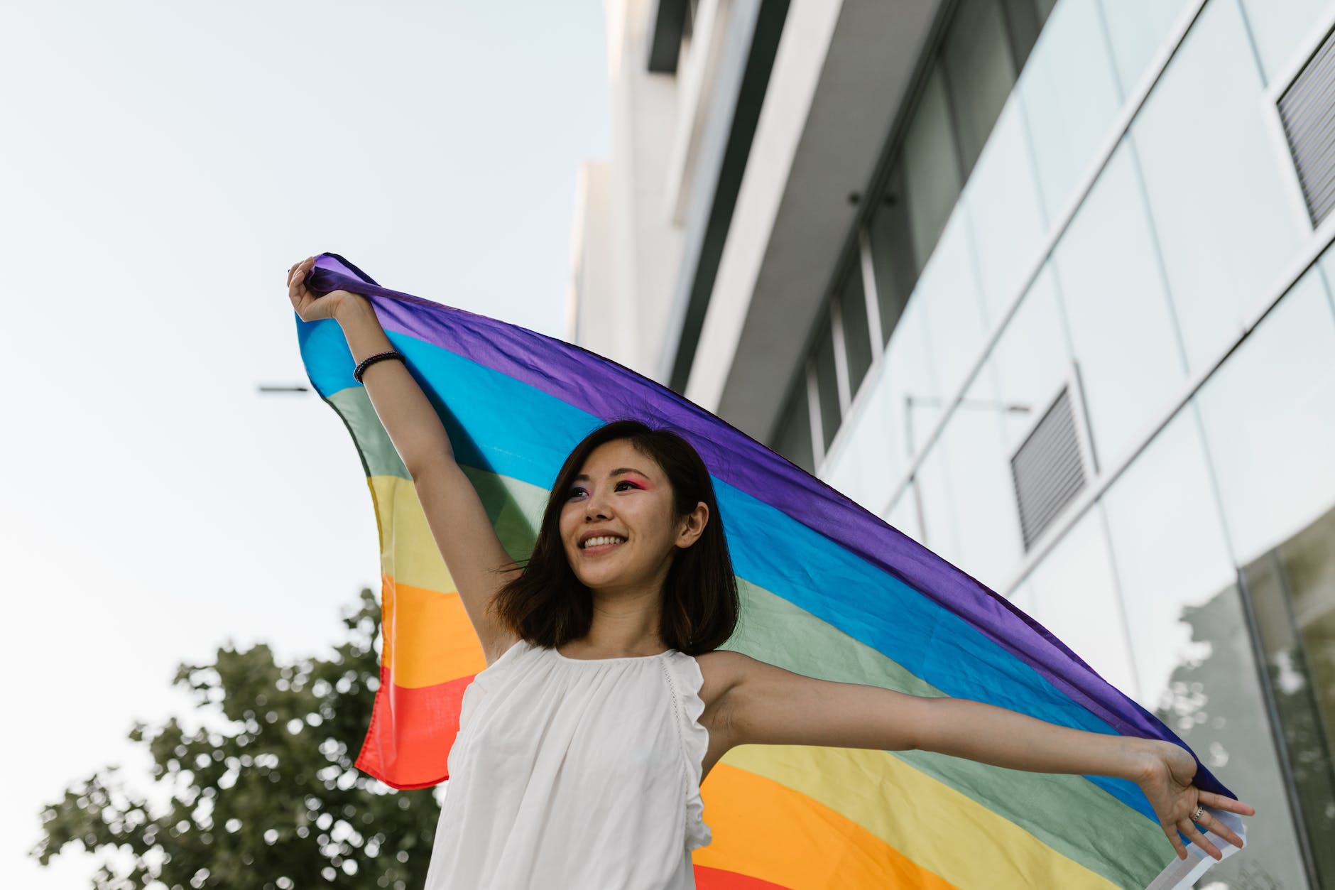 woman holding rainbow flag smiling