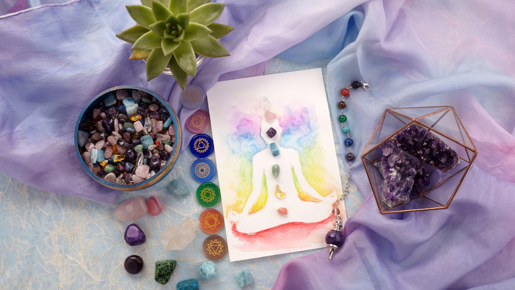 Crystals arranged around a chakra-illustrated figure with chakra symbols used in psychic readings and energy healing